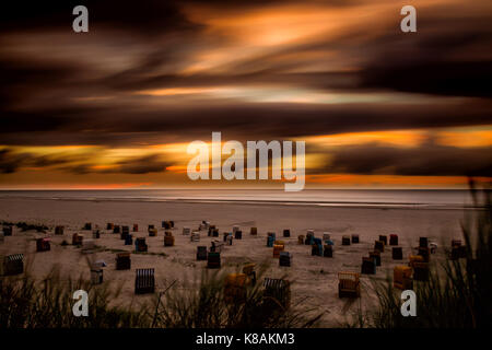 Sonnenuntergang und dramatischen Himmel über den Strand auf der Nordseeinsel Juist, Ostfriesland, Deutschland, Europa. Stockfoto