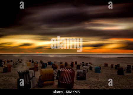 Sonnenuntergang und dramatischen Himmel über den Strand auf der Nordseeinsel Juist, Ostfriesland, Deutschland, Europa. Stockfoto