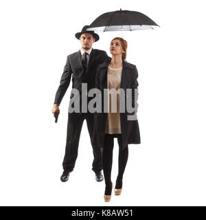 Eine Dame, die in förmlichen tragen mit ihrem Bodyguard Holding einen Regenschirm Stockfoto