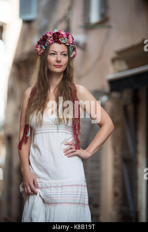 Detail der junge Frau im weißen Kleid mit Stirnband in den Straßen von Bonifacio, Frankreich Stockfoto