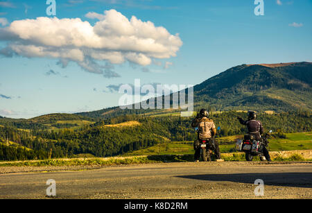 Volovets, Ukraine - September 15, 2017: zwei Radfahrer auf der Straße genießen Sie einen wunderschönen Sonnenuntergang in bergigen Landschaft Stockfoto