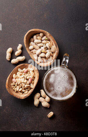 Lagerbier und Snacks auf Tisch aus Stein. Verschiedene Nüsse. Ansicht von oben Stockfoto