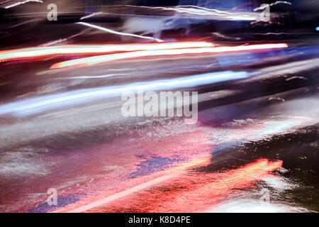 Nacht der Verkehr in der Stadt. Verschwommene Sicht der roten Auto Scheinwerfer, wie es im schweren Regen fährt. Abstrakte defokussierten Bild. Stockfoto