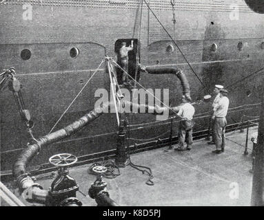 Betankung von RMS Berengaria im Jahr 1932. Der Cunard-Liner Berengaria (ehemals SS Imperator) war das größte Passagierschiff der Welt.- Zwischen 1934 und 1938 fuhr das Schiff über Cherbourg auf der Strecke Southampton nach New York. Während der Jahre des US-Verbots wurde Berengaria für ermäßigte Prohibition-Dodging-Kreuzfahrten verwendet, die den Spitznamen „Schnäppchen-Gebiet“ zogen. Stockfoto