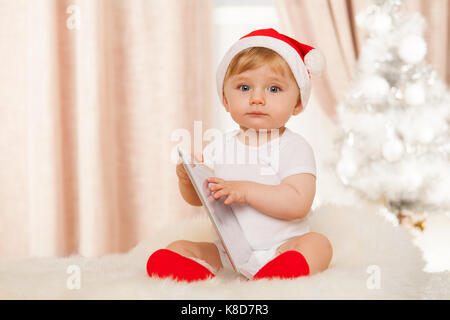 Cute Santa Baby hält Tablet Stockfoto