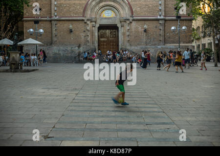 Junge, die mit Fußball in Plaça de la Virreina, Barcelona, Spanien 2017. Stockfoto