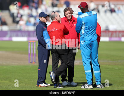 England Kapitän Eoin Morgan (links) Gespräche mit Westinseln Kapitän Jason Halter und die Schiedsrichter als Nass outfield Verzögerungen in der ersten Royal London einen Tag Länderspiel im Emirates Old Trafford, Manchester spielen. Stockfoto