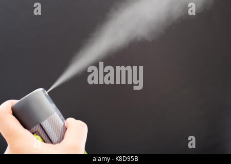 Deodorant können spritzen auf schwarzem Hintergrund Stockfoto