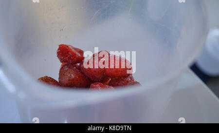 Gewürfelte Erdbeeren in einem metrischen Cup. Erdbeeren in einen Messbecher Stockfoto