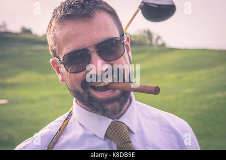 Portrait von lächelnden Golfspieler mit Zigarre mit Fahrer Stockfoto