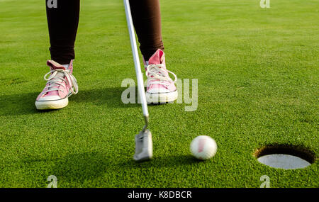 Pink Golfer teen geht in das Loch Stockfoto