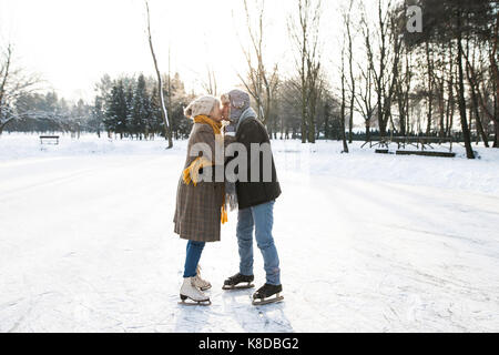 Älteres Paar im sonnigen Winter Natur Eiskunstlauf. Stockfoto