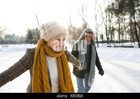 Älteres Paar im sonnigen Winter Natur Eiskunstlauf. Stockfoto