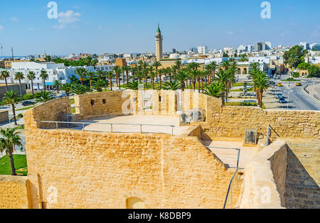 Der Blick von der Festung Ribat auf stadtbild von Monastir mit üppigen Palmengarten und hohen Minarett von Habib Bourguiba Moschee auf dem Hintergrund, Tunesien. Stockfoto