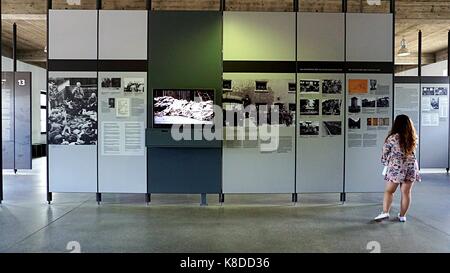 Eine junge Dame interessiert sich für Display Board im Museum in der KZ-Gedenkstätte Dachau in Dachau, Deutschland Stockfoto