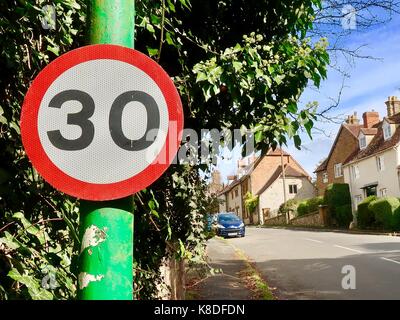 30 MPH Höchstgeschwindigkeit Zeichen auf einem grünen Post in Kineton, Warwickshire, Großbritannien. Stockfoto