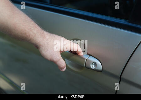 Der Mann öffnet die Autotür. Stockfoto