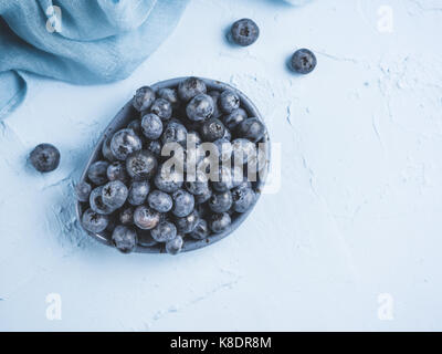 Heidelbeeren in der Platte auf blauem Hintergrund. Frische Heidelbeeren gepflückt. Copyspace. Top View oder flach Stockfoto