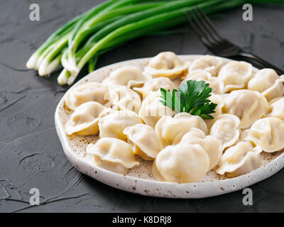 Traditionelle russische Maultaschen, Ravioli, Knödel mit Fleisch auf schwarzer konkreten Hintergrund. Russische speisen und russische Küche Konzept. Stockfoto