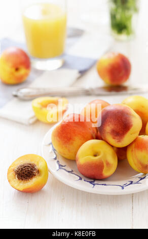 Still life with fresh ripe nectarine fruits  on white wooden table Stockfoto
