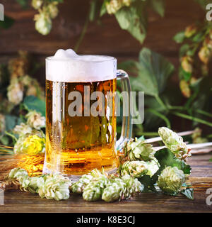 Ein Glas frisches Bier auf einer hölzernen Tisch. Stockfoto