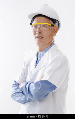 Portrait von asiatischen Senior Engineer mit harten Helm und Uniform, stehend auf weißem Hintergrund. Stockfoto