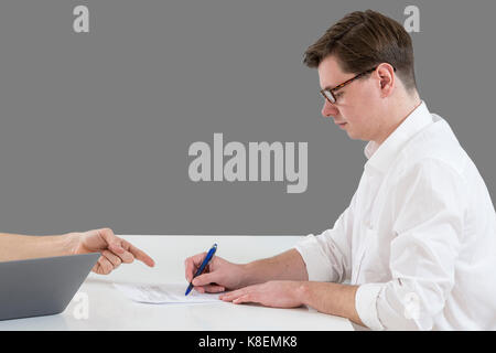 Nahaufnahme der männlichen Hand zeigen wo Sie unterzeichnen einen Vertrag, legalen Papieren oder Anmeldeformular. Stockfoto