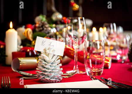 Esstisch für Weihnachtsessen mit Ort, Einstellungen, Dekorationen und Kerzen set Stockfoto