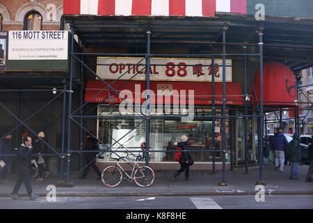 CHINATOWN, NEW YORK, USA - MÄRZ 2017 - Straße von Chinatown, unidentfied Menschen auf der Durchreise und ein Fahrrad ist verbunden mit Pol Stockfoto