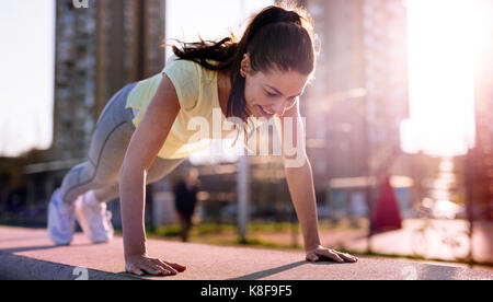 Bild der Frau tun, Push-ups im städtischen Bereich Stockfoto