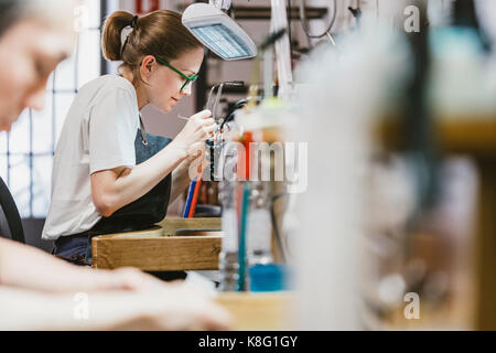 Weibliche und männliche Juweliere bei Workbench Stockfoto