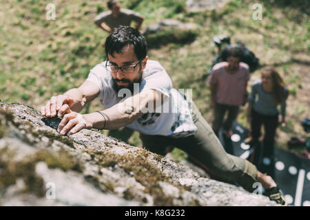 Friends männlichen Boulderer klettern Boulder, Lombardei, Italien Stockfoto