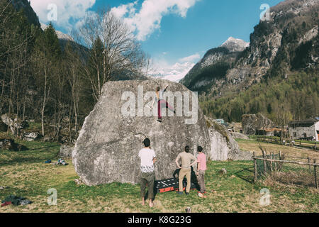 Ansicht der Rückseite des Erwachsenen bouldern Friends junge Frau klettern Boulder, Lombardei, Italien Stockfoto