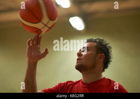 Student balancing Basketball auf Fingerspitzen Stockfoto
