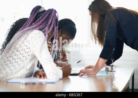 Lehrer im Klassenzimmer helfen Schüler studieren. Stockfoto