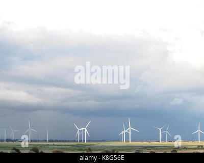 Windmühlen am Horizont unter einem bewölkten Himmel Stockfoto