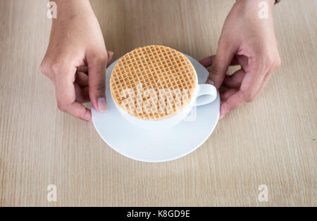 Nahaufnahme stroopwaffle auf heiße Tasse Kaffee servieren auf Holz Tisch und Platz kopieren Stockfoto