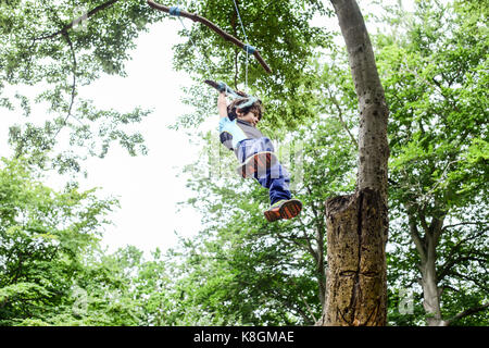 Junge schwingen auf hausgemachte Baum schwingen, Low Angle View Stockfoto