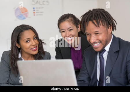 Unternehmer und Unternehmerinnen, im Büro, auf Laptop Stockfoto