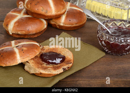 Hot Cross bun mit Erdbeermarmelade Stockfoto