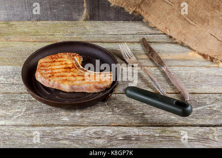 Gegrilltes Fleisch und Gemüse auf rustikalen Holztisch. pikante Saucen und Salz mit gegrilltem Steak auf einem rustikalen Holzmöbeln Zähler in einem Land serviert steakhous Stockfoto