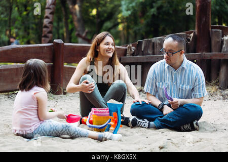 Happy Family verbringen lustige Zeit zusammen spielen im Sand