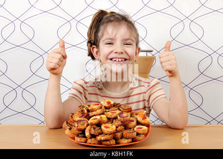 Glückliche kleine Mädchen mit Bruschette und Daumen hoch Stockfoto