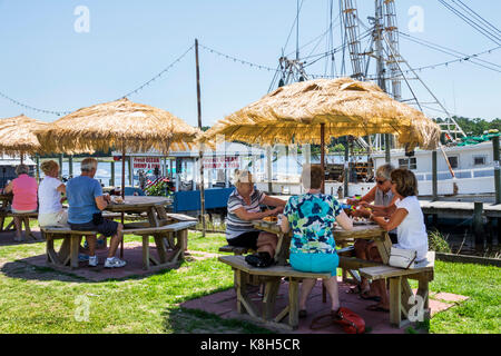 North Carolina, North Carolina, North Carolina, Calabash, Fischerdorf, Meeresfrüchte, regionale Küche, Speisen, Außentische im Freien, Strohschirm, Fischerboot, Dock, Captain Nan Stockfoto