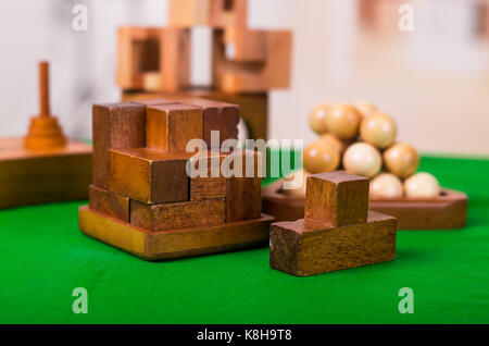 Holzblock Denksport puzzle am grünen Tisch in einer unscharfen Hintergrund Stockfoto