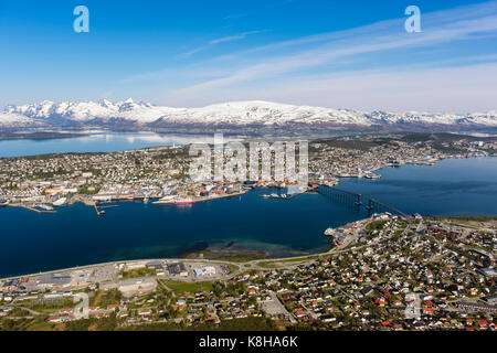 Hohe Blick über die Stadt auf der Insel Tromsoya mit schneebedeckten Berge in der Ferne vom Berg Storsteinen gesehen. Tromso, Troms, Norwegen, Skandinavien Stockfoto