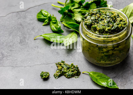 Chimichurri Sauce. Argentinische grüne Petersilie Basilikum Sauce Chimichurri für Grill asado in Glas, grauem Schiefer Hintergrund. Stockfoto