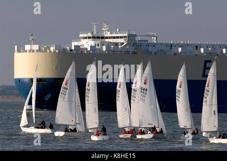 Eine Anzahl von kleinen Yachten laufen während des jährlichen Cowes Week Regatta auf der Isle of Wight vor einem großen Car carrier Schiff der Dorn-Kanal. Stockfoto