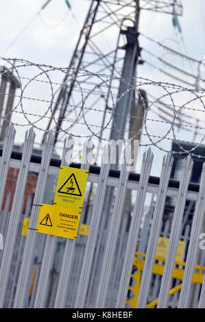 Eine Elektrizitätsgesellschaft sub Station mit palisade Fencing und Gefahr, die Gefahr des Todes gelbe Schilder auf die Einzäunung angebracht als Warnungen auf Eindringlinge Stockfoto