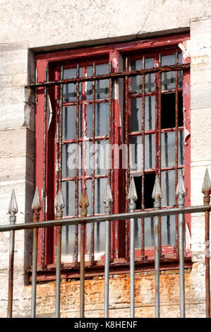 Eine alte shabby chic oder gebrochene Fenster in einem Zustand des Verfalls. Zertrümmerte Glas in einem alten Fenster in einem leerstehenden Gebäude. Vandalismus und beschädigten Eigentums. Stockfoto